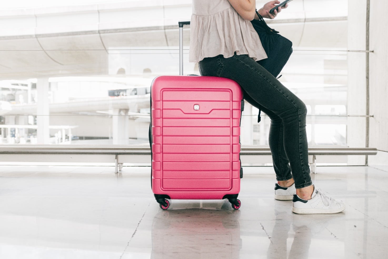 woman in white top and denim jeans sitting on red luggage 3597111 - Is your Suitcase a pain in the back?